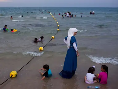 Pemandangan saat warga Palestina menghabiskan libur Idul Fitri di pantai Tel Aviv, Israel, Sabtu (16/6). Pemerintah Israel mengizinkan warga Palestina untuk berwisata di sepanjang garis pantai Mediterania selama Idul Fitri. (AP Photo/Oded Balilty)