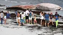 Orang-orang melihat bangkai paus sirip di pantai di Penmarc'h, Prancis barat pada Selasa (13/8/2019). Paus sepanjang 13 meter yang terdampar setelah mati di laut tersebut merupakan mamalia terbesar kedua di dunia. (Photo by Fred TANNEAU / AFP)