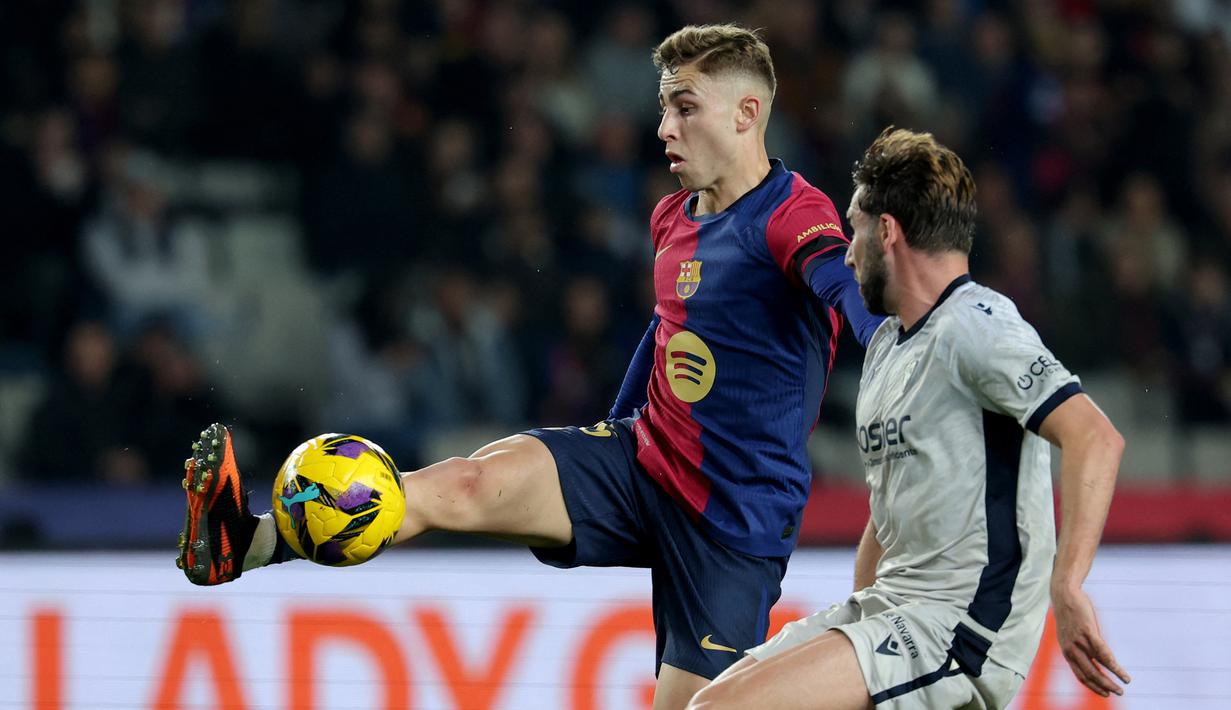 Pemain Barcelona, Fermin Lopez (kiri) berebut bola dengan Jon Moncayola dalam laga lanjutan Liga Spanyol 2024/2025 di Estadi Olimpic Lluis Companys, Barcelona, Spanyol, Jumat (27/03/2025) waktu setempat. (AFP/Lluis Gene)