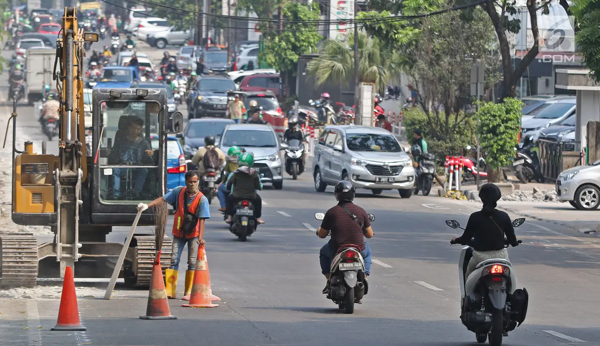 Kondisi lalu lintas saat pekerja menyelesaikan proyek revitalisasi trotoar di kawasan Kemang, Jakarta, Jumat (29/6/2019). Kepala Dinas Binamarga DKI Jakarta mengatakan anggaran pembenahan trotoar Kemang dan Jalan Prof Doktor Satrio Jakarta Selatan capai Rp 100 miliar. (Liputan6.com/Herman Zakharia)