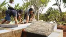 Pelanggar PSBB dihukum membersihkan makam di kawasan Stadion Pakansari, Kabupaten Bogor, Minggu (6/9/2020). Pemkab Bogor menghukum pelanggar PSBB dengan denda Rp 100 ribu serta sanksi sosial seperti membersihkan area makam, push up, dan mempraktikkan prosesi pemakaman. (Liputan6.com/Herman Zakharia)