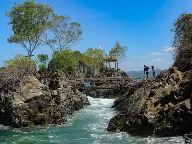 Warga asal Lamongan berjalan menikmati keindahan Lembah Watu Pawon di Desa Wisata Nglebeng, Kecamatan Panggul, Trenggalek, Jumat (01/09/2023). (merdeka.com/Arie Basuki)