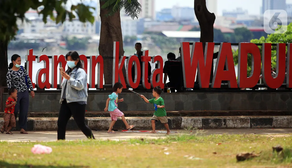 Anak-anak berlarian saat mengunjungi Taman Kota Waduk Pluit di Penjaringan, Jakarta Utara, Minggu (27/12/2020). Taman Kota Waduk Pluit dibuka kembali setelah di tutup pada libur Natal, namun banyak warga yang berwisata tidak menerapkan protokol kesehatan. (Liputan6.com/Johan Tallo)