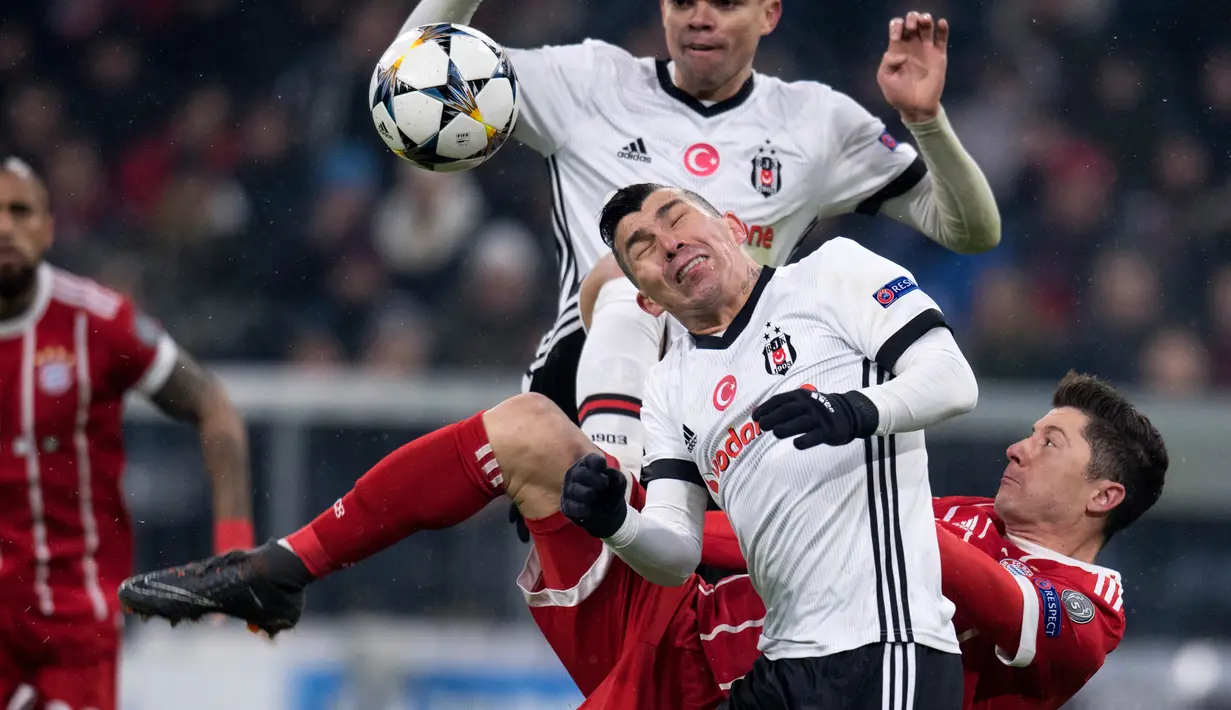 Pemain Bayern Munchen, Robert Lewandowski berebut bola dengan pemain Besiktas, Gary Alexis Medel dan Pepe pada leg pertama babak 16 besar Liga Champions di Allianz Arena, Selasa (20/2). Bayern melumat Besiktas lima gol tanpa balas. (Sven Hoppe/dpa via AP)