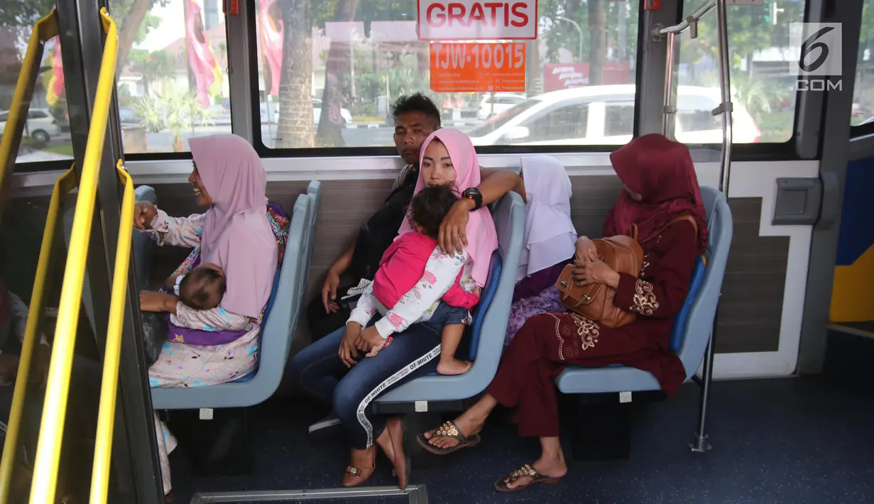 Warga berada di dalam bus tingkat wisata keliling Ibu Kota di kawasan Monas, Jakarta, Sabtu (16/6). Libur Hari Raya Idul Fitri dimanfaatkan oleh sebagian masyarakat Jakarta untuk berlibur ketempat wisata bersama keluarga. (Liputan6.com/Arya Manggala)