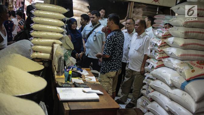 Tim Satgas Pangan Polda Metro Jaya dan Perum Bulog berbincang dengan pedagang saat meninjau harga beras di Pasar Tomang Barat, Jakarta, Rabu (21/11). Kegiatan tersebut untuk memantau stabilitas harga beras medium di pasaran. (Liputan6.com/Faizal Fanani)