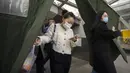Para komuter yang mengenakan masker untuk melindungi diri dari COVID-19 berjalan keluar dari stasiun kereta bawah tanah di Beijing, China, Rabu (15/12/2021). China mendeteksi kasus kedua varian omicron pada seorang pria berusia 67 tahun. (AP Photo/Mark Schiefelbein)