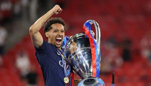 Marquinhos saat mengangkat trofi Liga Champions usai PSG mengalahkan Arsenal pada adu tendangan penalti. (Odd ANDERSEN / AFP)