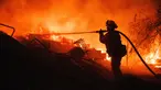 Seorang petugas pemadam kebakaran mengambil selang ke properti yang terbakar saat berjuang melawan Kebakaran Fairview Senin (5/9/2022) dekat Hemet, California. Api Fairview menyala setelah pukul dua siang waktu setempat dan dengan cepat menghanguskan 2.000 hektar, menghancurkan setidaknya tujuh bangunan dan merusak beberapa lagi di dekat kota Hemet di Riverside County, menurut Cal Fire. (AP Photo/Ethan Swope)