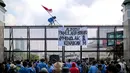 Seorang mahasiswa mengibarkan bendera Merah Putih di gerbang Gedung DPR saat melakukan aksi, Jakarta, Selasa (6/9/2022). Dalam aksi tersebut mahasiswa menolak keputusan pemerintah menaikkan harga bahan bakar minyak (BBM) bersubsidi dan meminta pemerintah untuk meninjau ulang keputusan tersebut. (Liputan6.com/Faizal Fanani)