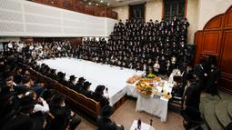 Orang-orang Yahudi Ultra-Ortodoks dari dinasti Hasid Sadigura merayakan Hari Raya Tu Bishvat atau Tahun Baru Pohon di Yerusalem, 5 Februari 2023. Saat perayaan Tahun Baru Pohon, orang-orang Yahudi Ultra-Ortodoks berkumpul dengan para rabi mereka di sekitar meja panjang berisi piring-piring berisi beberapa jenis buah-buahan. (AP Photo/Ariel Schalit)