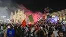 Suporter merayakan kemenangan Italia atas Inggris pada pertandingan final Euro 2020 di depan Katedral Duomo, Milan, Italia, Senin (12/7/2021). Italia menjuarai Euro 2020 usai mengalahkan Inggris lewat drama adu penalti pada pertandingan final. (AP Photo/Luca Bruno)