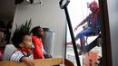 Pasien anak mengamati superhero Spiderman membersihkan kaca jendela kamar sebuah rumah sakit di Birmingham, Rabu (11/10). Sekelompok superhero bekerja membersihkan jendela rumah sakit untuk menghibur anak- anak yang sedang sakit. (AP Photo/Brynn Anderson)