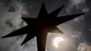 Bulan mulai menutupi matahari saat gerhana matahari cincin di Bangkok, Thailand, Kamis (26/12/2019). Gerhana matahari cincin ini dapat diamati dari sejumlah wilayah mulai dari Afrika timur, seluruh Asia, Samudera India, dan Australia utara. (Lillian SUWANRUMPHA/AFP)