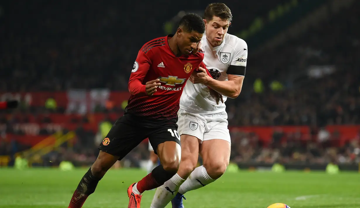 Aksi Marcus Rashford melewati pemain Burnley pada laga lanjutan Premier League berlangsung di stadion Old Trafford, Manchester, Rabu (30/1). Man United ditahan imbang 2-2 kontra Burnley. (AFP/Paul Ellis)