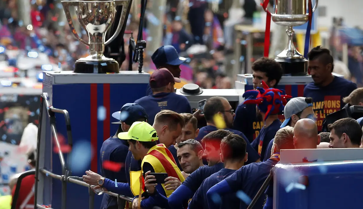 Pelatih Barcelona, Ernesto Valverde (tengah) mengambil gambar dengan handphone dari atas bus di Barcelona, (30/4/2018). Barcelona memastikan gelar setelah menang 4-2 atas Deportivo. (AP/Manu Fernandez)