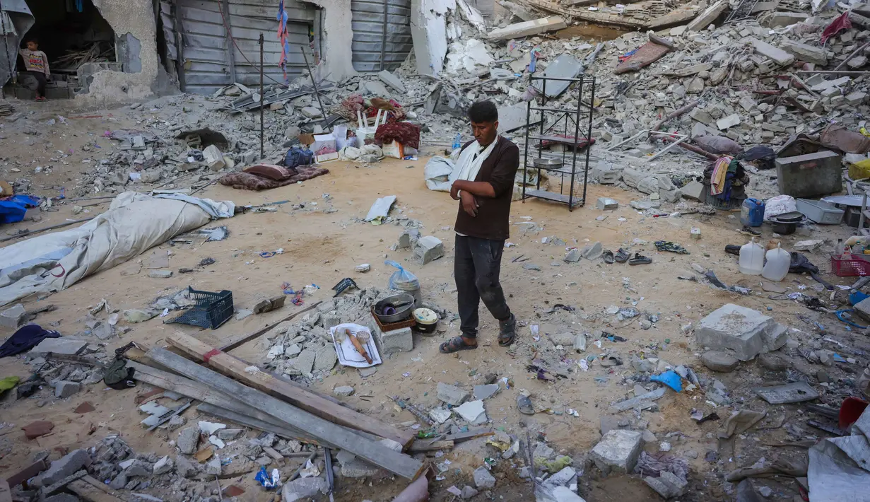 Seorang pria berjalan di tengah reruntuhan rumah yang hancur akibat serangan Israel di Khan Younis, Jalur Gaza selatan, pada Rabu 29 Oktober 2025. Di sisi lain, Hamas menegaskan tetap berkomitmen pada kesepakatan gencatan senjata di Gaza. Hamas juga mengatakan PM Israel Benjamin Netanyahu sedang mencari alasan untuk mengingkari kewajiban Israel dalam kesepatan damai. (BASHAR TALEB/AFP)