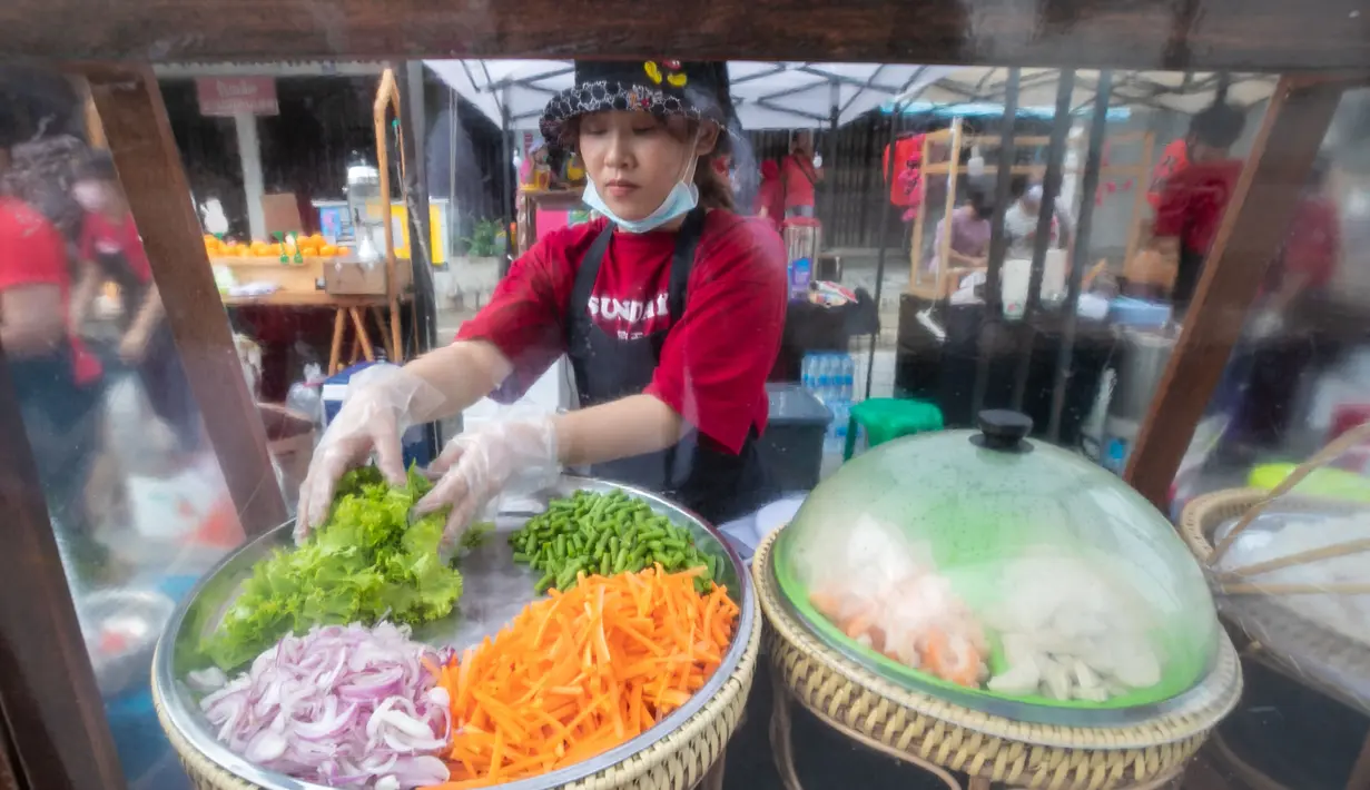 Seorang penjual menyiapkan sayuran dalam festival kuliner di kota tua Phuket, Thailand (13/9/2020). Festival selama dua hari itu digelar untuk mendorong pariwisata dan perekonomian setempat. (Xinhua/Zhang Keren)
