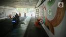 Petugas Penanganan Prasarana dan Sarana Umum (PPSU) menyelesaikan lukisan mural pada tembok kolong Semanggi, Jakarta, Jumat (7/7/2023). Pembuatan mural tersebut guna mempercantik kawasan tersebut yang selalu dilewati pengguna jalan. (Liputan6.com/Faizal Fanani)