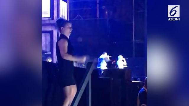 Sesosok wanita yang berdiri di samping panggung konser Eminem mencuri perhatian banyak orang yang menonton.