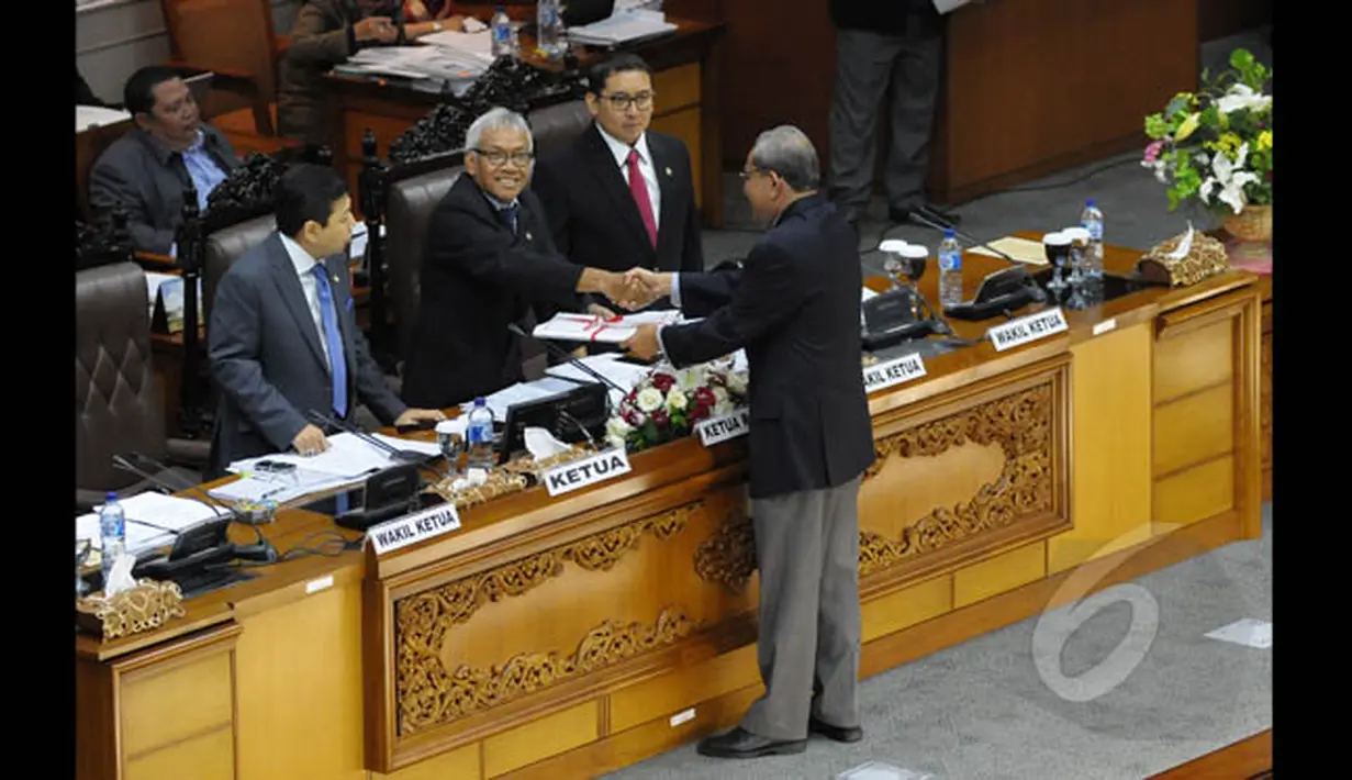 Ketua Komisi II Rambe Kamaru Saman memberikan Perppu Nomor 1 Tahun 2014 tentang Pilkada langsung, kepada Wakil ketua DPR RI Agus Hermanto (tengah) dalam sidang Paripurna, Jakarta, Selasa (20/1/2015). (Liputan6.com/Andrian M Tunay)