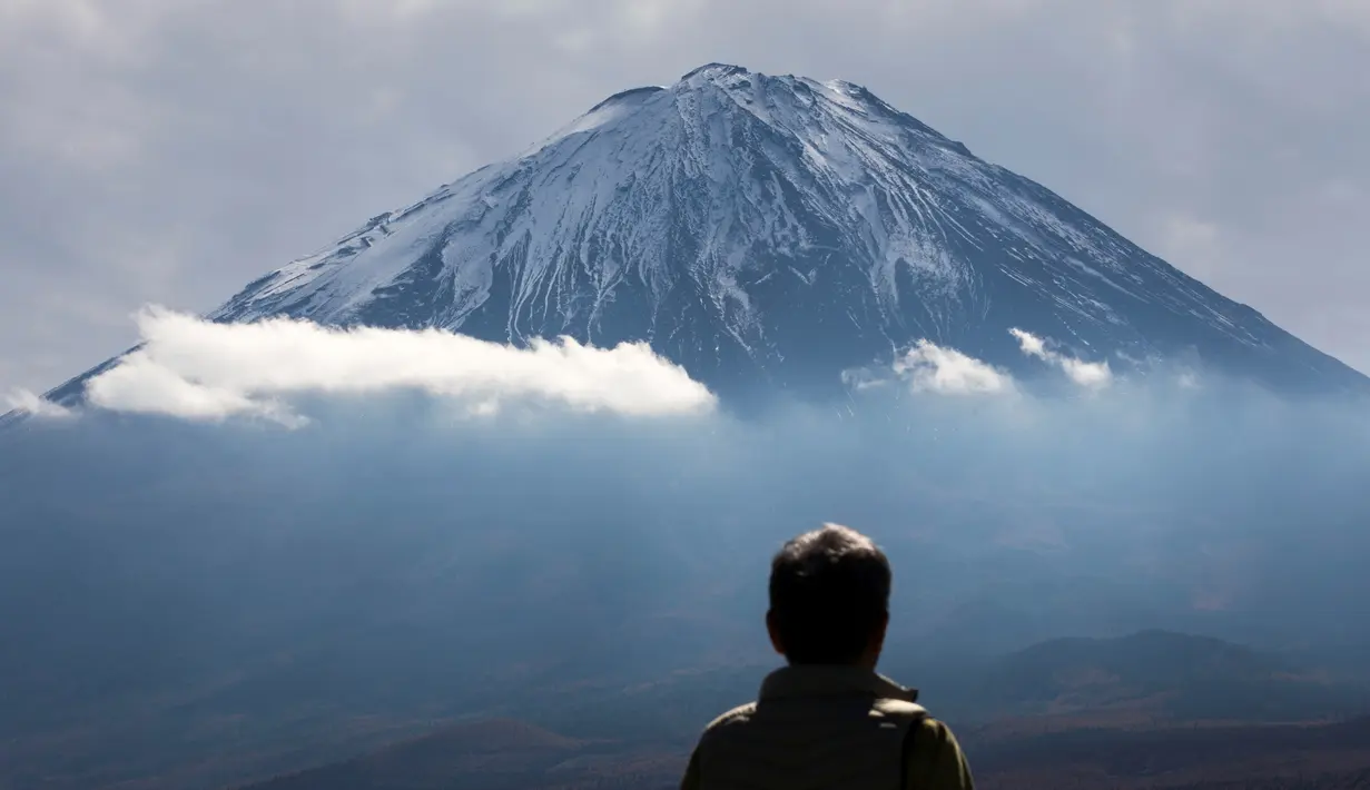 Seorang turis melihat Gunung Fuji dari Fujikawaguchiko, Prefektur Yamanashi, Jepang (1/11). Gunung Fuji adalah gunung tertinggi di Jepang, terletak di perbatasan Prefektur Shizuoka dan Yamanashi, di sebelah barat Tokyo. (AFP Photo/Behrouz Mehri)