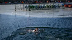 Seorang pria berenang di sebuah danau yang airnya sebagian membeku di Beijing pada Senin (30/12/2019). Penduduk lokal banyak menggemari kebiasaan berenang di musim dingin dimana banyak sungai dan danau-danau mulai membeku. (WANG ZHAO / AFP)