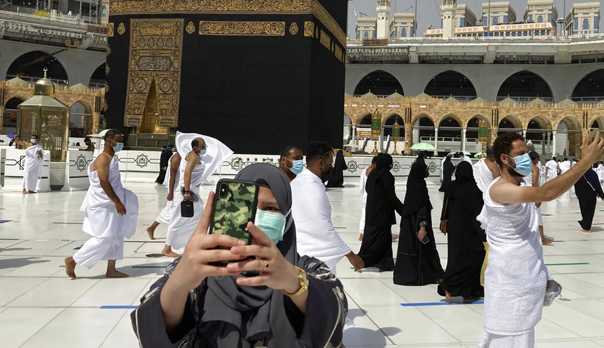 Umat muslim memakai masker untuk membantu menghentikan penyebaran virus corona COVID-19 saat berswafoto di Masjidil Haram, Makkah, Arab Saudi, Minggu (30/5/2021). (AP Photo/Amr Nabil)
