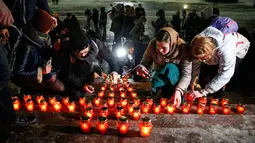 Warga menempatkan lilin di Katedral Kristus Juruselamat Moskow, Rusia, Senin (12/2). Mereka menyalakan 71 lilin sebagai simbol jumlah korban tewas dalam kecelakaan pesawat Rusia di Moskow. (Maxim ZMEYEV / AFP)