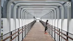 Pekerja berdiri di jembatan penyeberangan orang (JPO) Bundaran Senayan, Jakarta, Senin (21/1). JPO Bundaran Senayan telah berdiri kokoh disertai konstruksi yang lengkap terpasang. (Liputan6.com/Faizal Fanani)