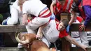 Seorang pria tak dapat menghindari serudukan banteng di Run Bull dalam Festival San Fermin di Pamplona. Aksi seperti ini telah dikecam oleh pecinta binatang (10/07/2014) (AFP PHOTO/Ander GILLENEA)