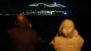 Warga menyaksikan kapal pesiar MSC World Europa meninggalkan pelabuhan Saint-Nazaire, Prancis barat pada 26 Oktober 2022.  Kapal raksasa ini memiliki kapasitas 6.762 penumpang. (AFP/Sebastien Salom Gomis)