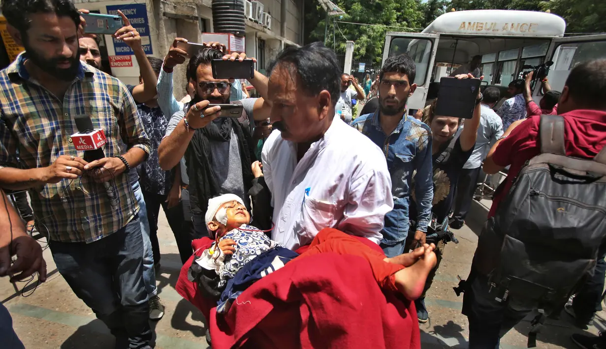 Seorang gadis yang terluka dibawa kerumah sakit setelah bus yang dinaikinya terjun ke jurang di wilayah Kishtwar di negara bagian Jammu dan Kashmir (1/7/2019). Insiden tersebut merupakan yang kedua dalam kurun waktu sepekan. (AP Photo/Channi Anand)