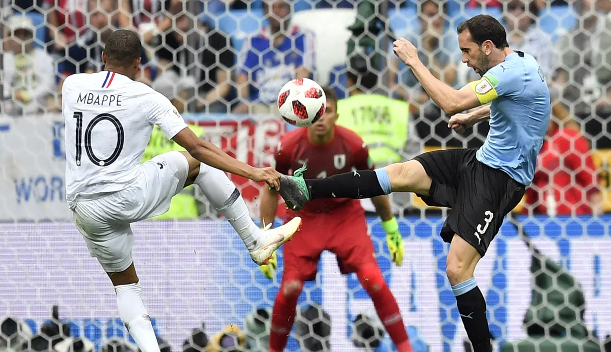 Striker Prancis, Kylian Mbappe, berebut bola dengan bek Uruguay, Diego Godin, pada laga perempat final Piala Dunia di Stadion Nizhny Novgorod, Nizhny Novgorod, Jumat (6/7/2018). Prancis menang 2-0 atas Uruguay. (AP/Martin Meissner)