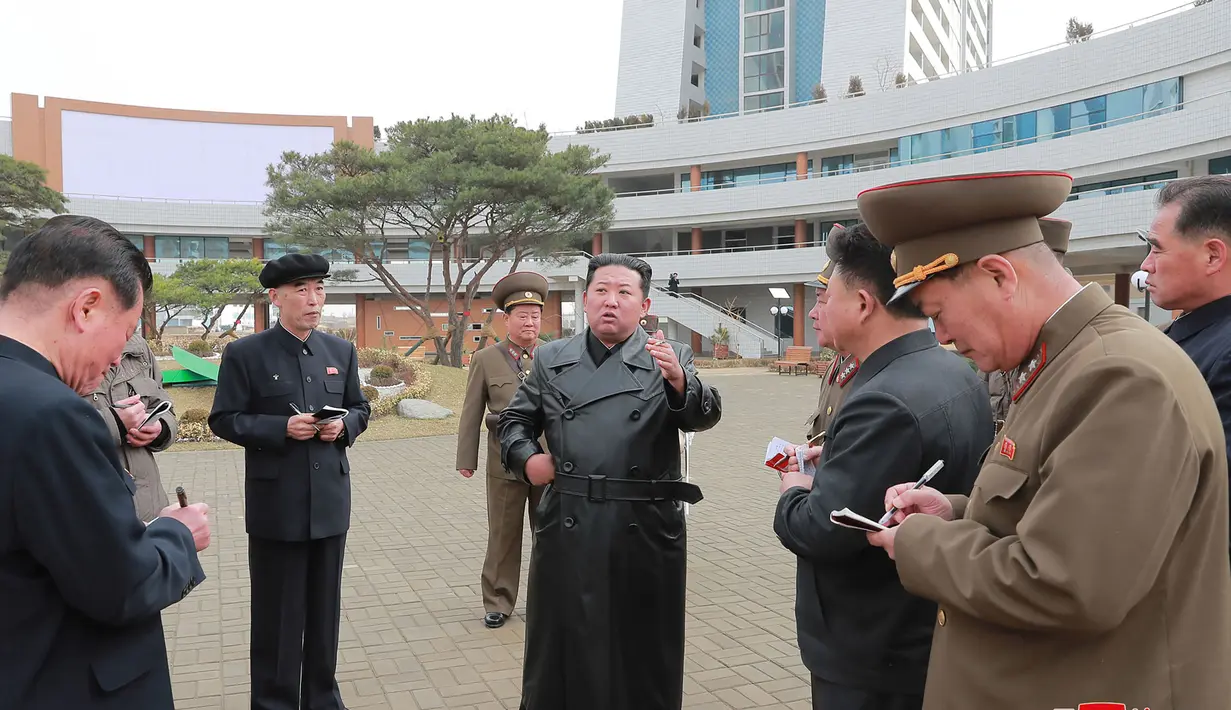 Pemimpin Korea Utara Kim Jong Un (tengah) berbincang dengan para pejabat saat memeriksa lokasi kompleks perumahan 10.000-flat yang sedang dibangun di Pyongyang (16/3/2022). Kim telah menghadiri upacara peletakan batu pertama situs tersebut Maret lalu. (AFP/STR/KCNA Via KNS)