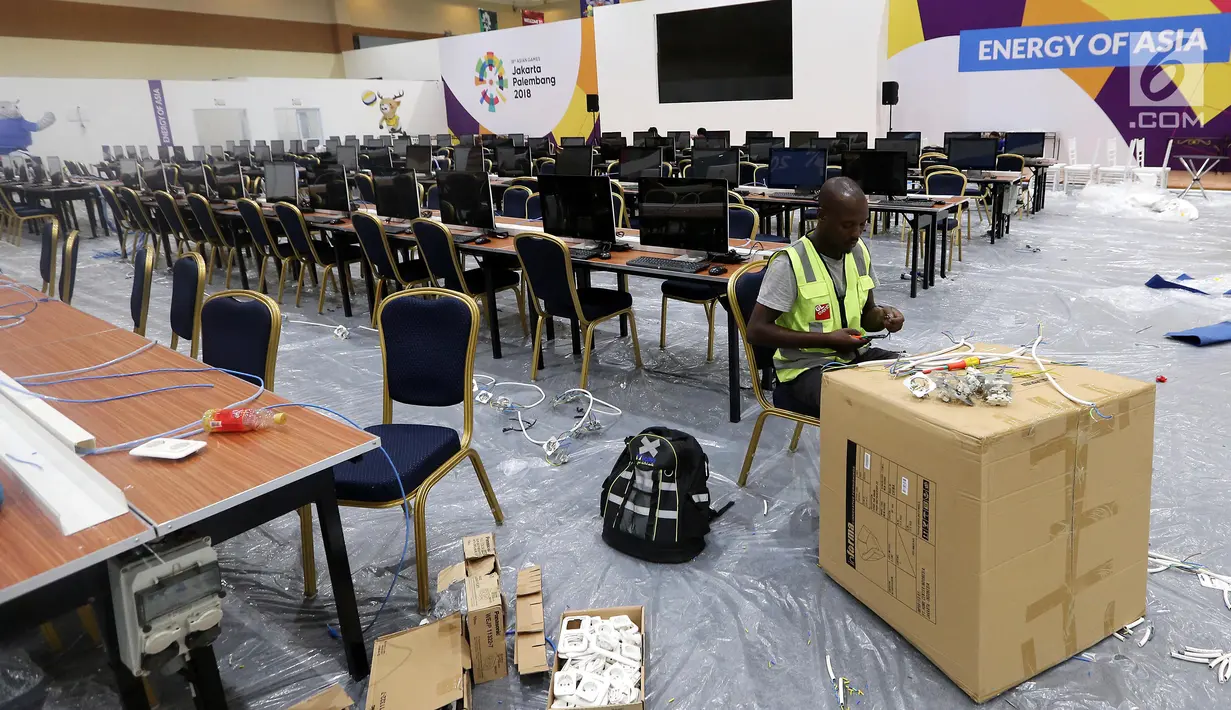 Pekerja memotong kabel di Main Press Center (MPC) atau media center bagi jurnalis untuk pelaksanaan Asian Games 2018 terus dibangun di Exhibition Hall JCC, Jakarta, Kamis (9/8). MPC akan beroperasi pada 10 Agustus. (Liputan6.com/Fery Pradolo)