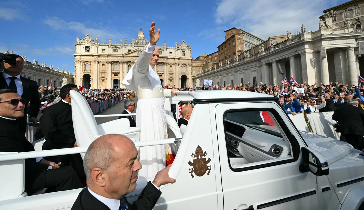 Menaiki kendaraan kepausan "popemobile", Paus Leo XIV menyapa puluhan ribu umat yang hadir di Lapangan Santo Petrus, Basilika, Vatikan, untuk menyaksikan pelantikannya pada Minggu, 18 Mei 2025. (Andreas SOLARO/AFP)