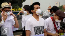 Artis dan aktivis menggelar aksi turun kejalan solidaritas #melawanasap di Patung Kuda kawasan Merdeka Barat, Jakarta, Jumat (9/10/2015). Aksi mendesak pemerintah beri pelayanan maksimal kepada seluruh korban kebakaran hutan. (Liputan6.com/Faizal Fanani)