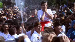 Remaja wanita digendong sebelum dipeluk oleh pasangan prianya saat festival Omed-omedan di Bali, Kamis (29/3). Festival yang dilakukan sehari setelah Hari Raya Nyepi itudigelar untuk memupuk persaudaraan pemuda dan pemudi desa. (AP Photo/Firdia Lisnawati)
