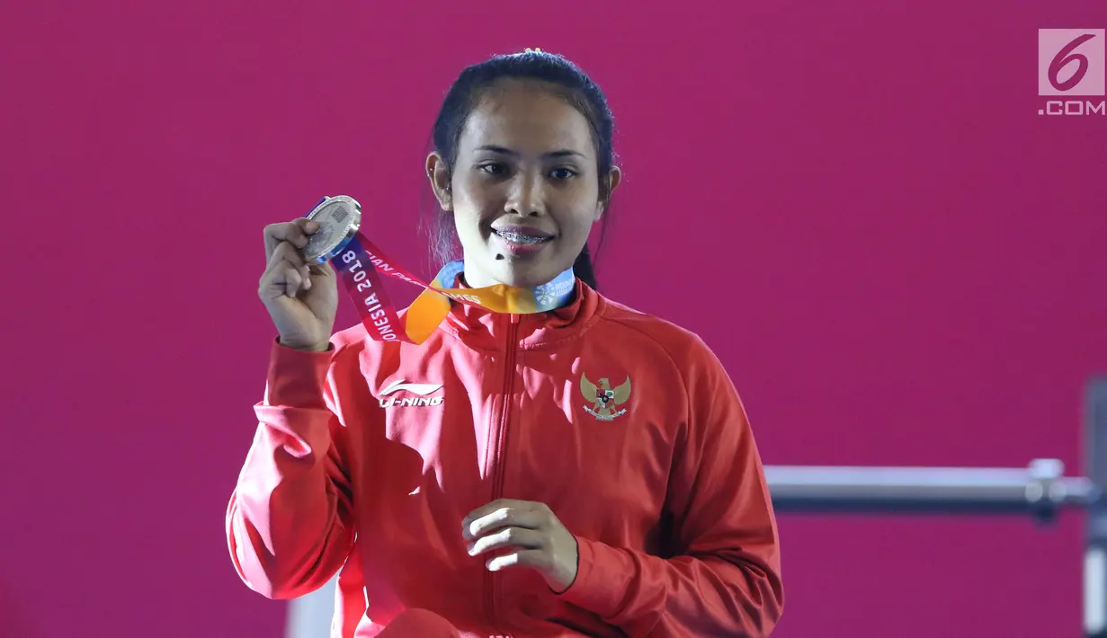 Atlet Para Powerlifting Indonesia, Ni Nengah Widiasih memperlihatkan medali perak Womens Up to 41.00kg Asian Para Games 2018 di Jakarta, Minggu (7/10). Ni Nengah Widiasih berhasil melakukan total angkatan 97 kg. (Liputan6.com/Helmi Fithriansyah)