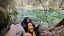 Dengan latar pemandangan danau yang sangat indah, Rachel Vennya berpose bersama kedua anaknya mengenakan puffer jacket berwarna hitam. [Foto: Instagram/rachelvennya]