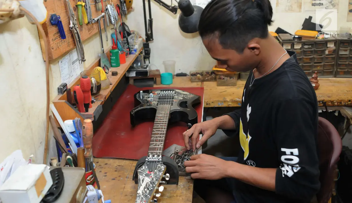 Pengrajin melakukan finishing pembuatan gitar di Syukey Guitars, Cirendeu, Ciputat Timur (3/4). Gitar ini tidak hanya dipasarkan di dalam negeri saja, tetapi juga dipasarkan hingga Amerika dan Eropa. (Merdeka.com/Arie Basuki)