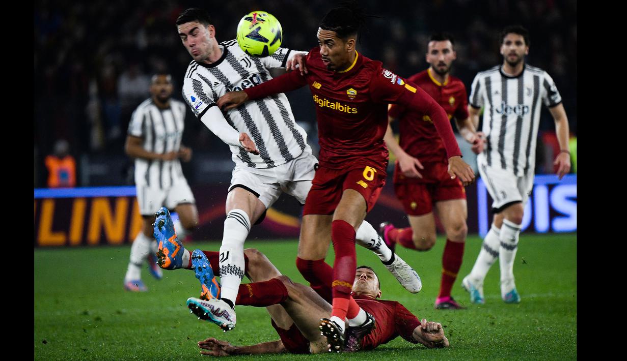 Pemain Juventus, Dusan Vlahovic (kiri) berebut bola dengan pemain AS Roma, Chris Smalling pada laga pekan ke-25 Liga Italia 2022/2023 yang berlangsung di Stadio Olimpico, Senin (06/03/2023) dini hari WIB. (AFP/Filippo Monteforte)
