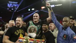 Petinju Inggris Tyson Fury merayakan kemenangannya atas petinju AS Deontay Wilder pada pertandingan tinju kelas berat WBC di Las Vegas (23/2/2020). Tyson Fury berhasil memenangkan pertarungan di ronde ketujuh. (AP Photo/Isaac Brekken)