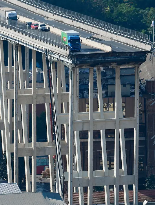 Sejumlah kendaraan berada di atas jembatan Morandi, dekat dengan bagian jalan layang yang runtuh, di kota Genoa, italia, Selasa (14/8). Seperti diketahui, bagian jalan layang jembatan Morandi sepanjang 200 meter ambruk. (Luca Zennaro/ANSA via AP)