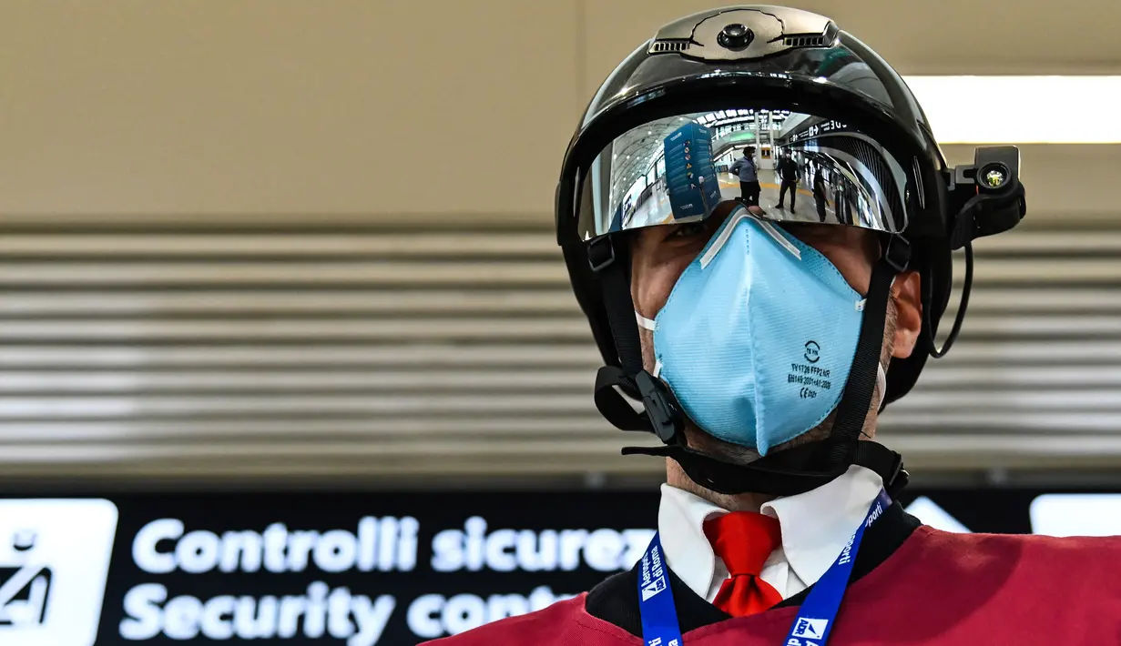 Petugas memperlihatkan termoscanner portabel "Smart-Helmet" untuk memeriksa suhu penumpang dan sesama staf di terminal keberangkatan bandara Fiumicino Roma, Italia pada 5 Mei 2020. Hal ini dilakukan guna menyaring orang yang memiliki gejala infeksi virus corona. (ANDREAS SOLARO/AFP)
