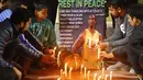 Sejumlah warga menyalakan lilin untuk mengenang wafatnya Kobe Bryant di Gurgaon, India, Senin(26/1). Akibat kecelakaan helikopter, legenda NBA itu wafat bersama sang putri. (AFP/Manoj Kumar)
