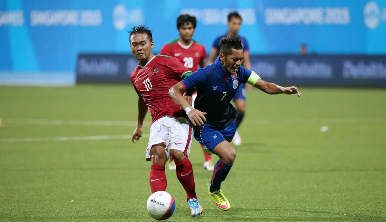 Gelandang timnas Indonesia U-23, Wawan Pebriyanto (kiri) berebut bola dengan Mony Udom P (Kamboja) di penyisihan Grup A Sea Games 2015 di Stadion Jalan Besar, Singapura, (6/6/2015). Indonesia unggul 6-1 atas Kamboja. (Liputan6.com/Helmi Fithriansyah)