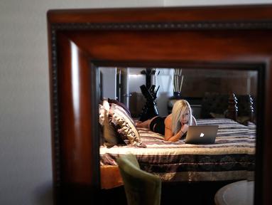 Pekerja seks komersil, Paris Envy bermain laptop di rumah bordil Love Ranch di Crystal, Nevada, AS, (27/4). Koalisi kelompok agama dan aktivis perdagangan anti-seks meluncurkan referendum melarang keberadaan rumah bordil di Nevada. (AP Photo/John Locher)