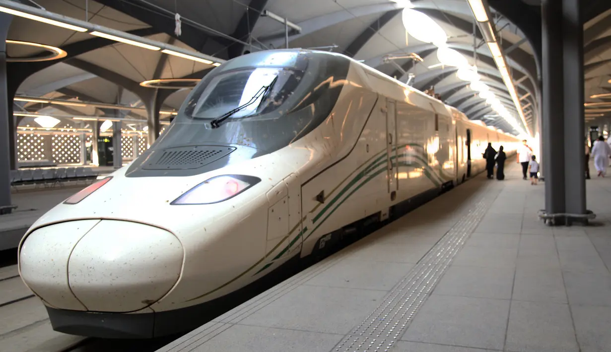 Para penumpang berjalan di peron ketika kereta api kecepatan tinggi Haramain resmi beroperasi di stasiun kereta Makkah, Kamis (11/10). Kereta cepat Haramain akan beroperasi empat hari dalam sepekan, dari Kamis hingga Minggu. (BANDAR ALDANDANI/AFP)